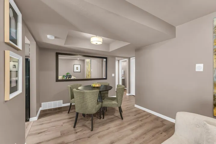 Wood-finish flooring, recessed ceiling detail, and ceiling-mounted light fixture
