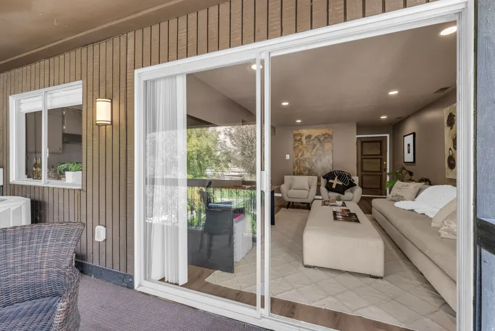 Sliding glass doors leading to a living area with recessed lighting and wood-finish flooring
