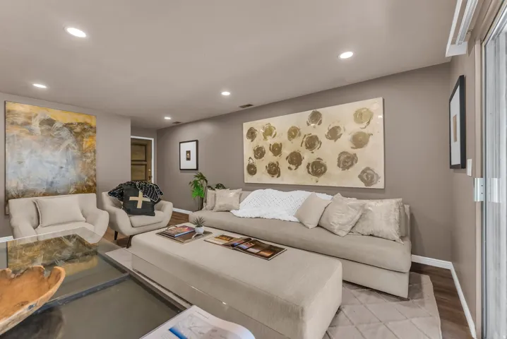 Recessed ceiling lighting, durable wood-finish flooring, and a sliding glass door