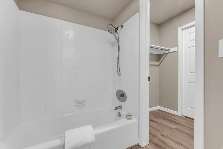 Bathtub with white tile surround and chrome fixtures