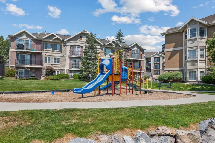 Community playground featuring a slide, swings, and climbing structure