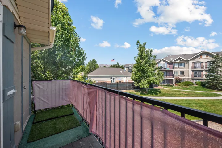 Balcony with privacy screening, durable railing, and exterior lighting fixture