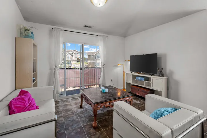 Sliding glass door leading to a private balcony, complemented by dark-toned floor tiling