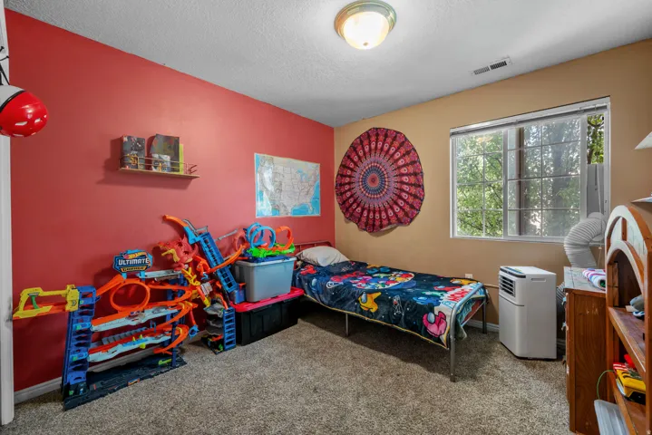 Wall-to-wall carpeting with a neutral finish, dual-tone wall paint, and a window with natural light
