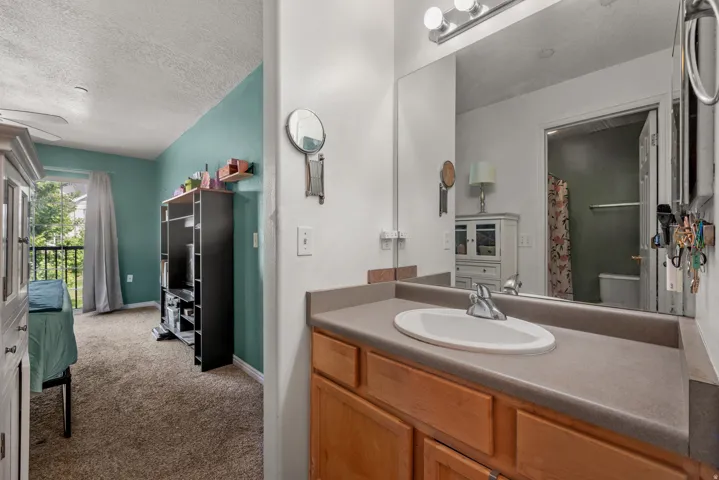 Bathroom vanity with an integrated sink, wood-finish cabinetry, and a large wall-mounted mirror