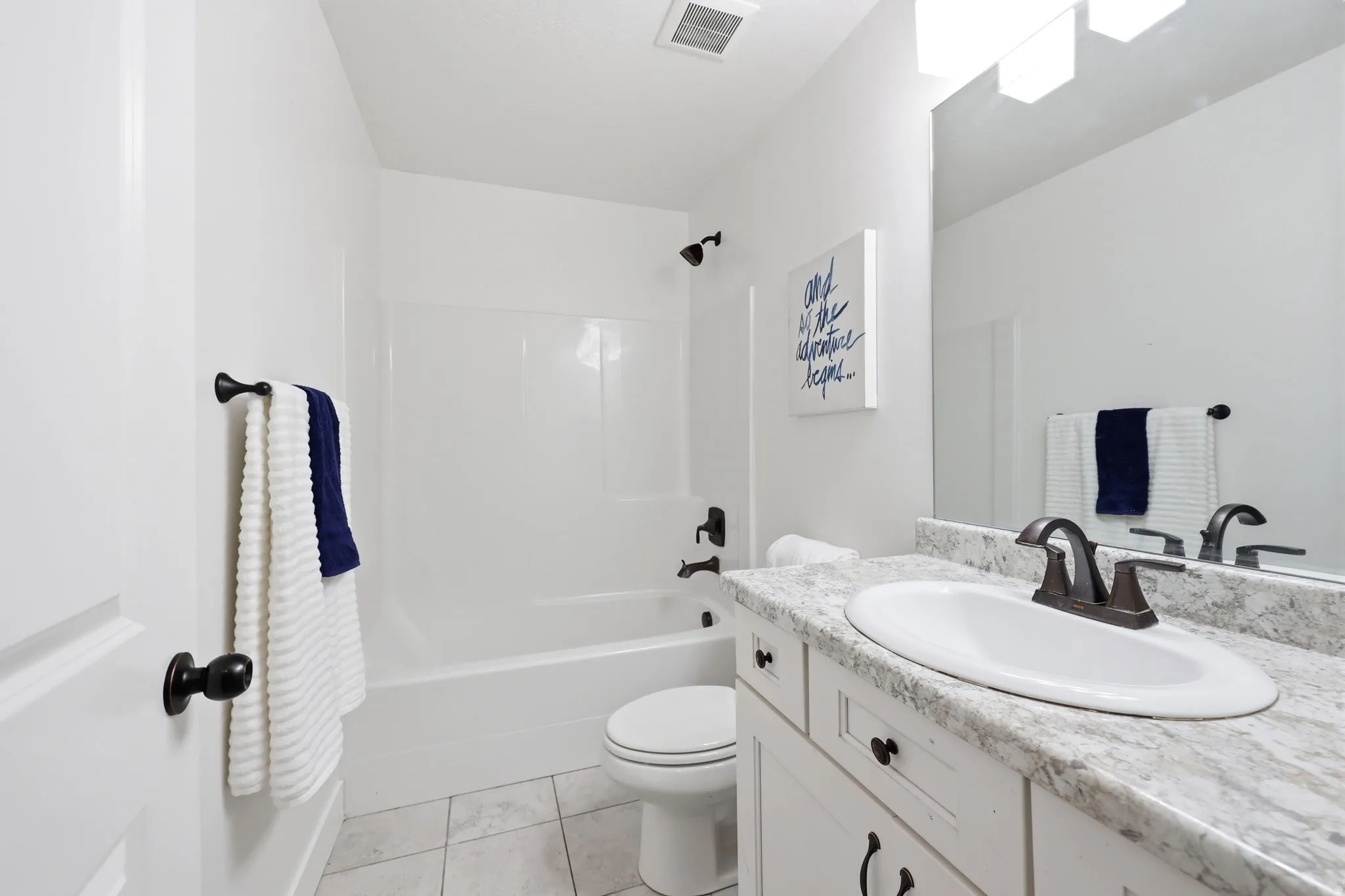 Bathroom featuring a white vanity with a light-toned countertop, an integrated sink, and an oil-rubbed bronze faucet