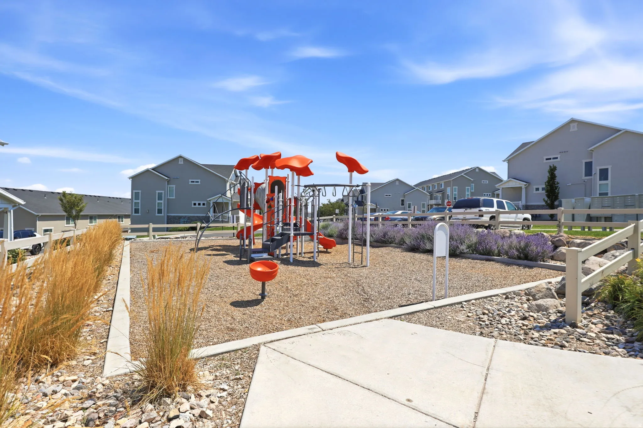 Community playground featuring a multi-level structure with slides, swings, and climbing elements