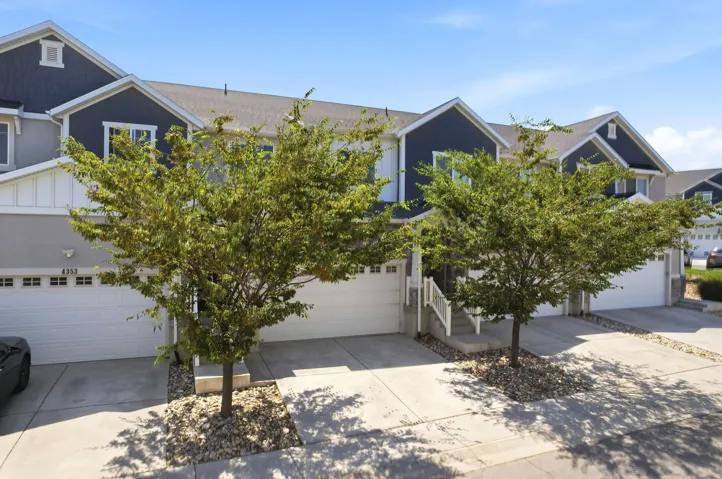 Contemporary townhome-style residences featuring dark blue siding accents and light gray exterior walls