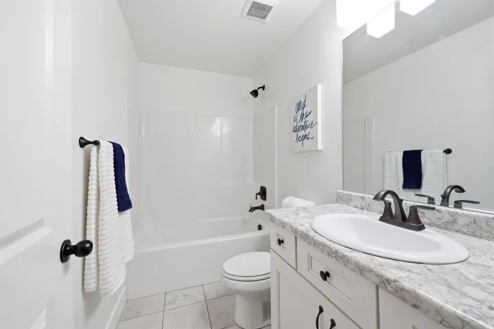 Bathroom featuring a white vanity with a light-toned countertop, an integrated sink, and an oil-rubbed bronze faucet