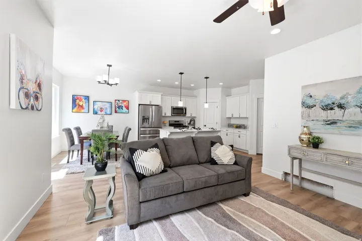 Open-concept living area featuring light wood-finish flooring, recessed lighting, and a contemporary ceiling fan