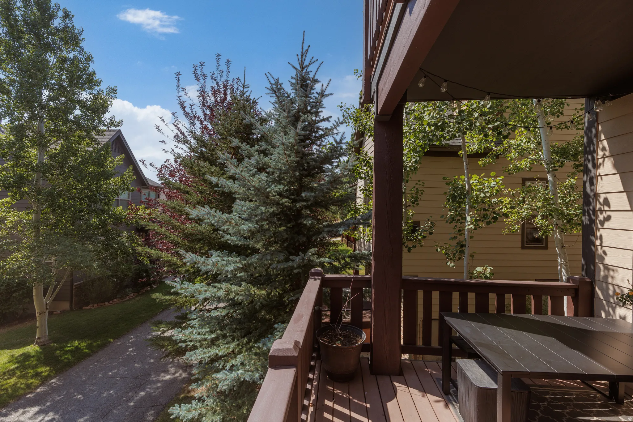Spacious outdoor balcony with composite decking, dark wood railings,