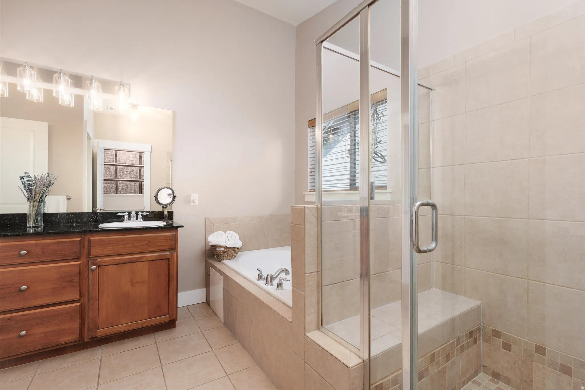 Wood-finish vanity with a dark countertop and undermount sink