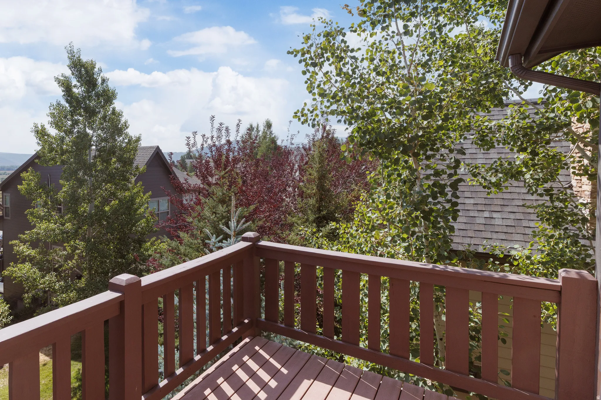 Outdoor deck featuring wooden railings and decking with views to Iron Mountain.