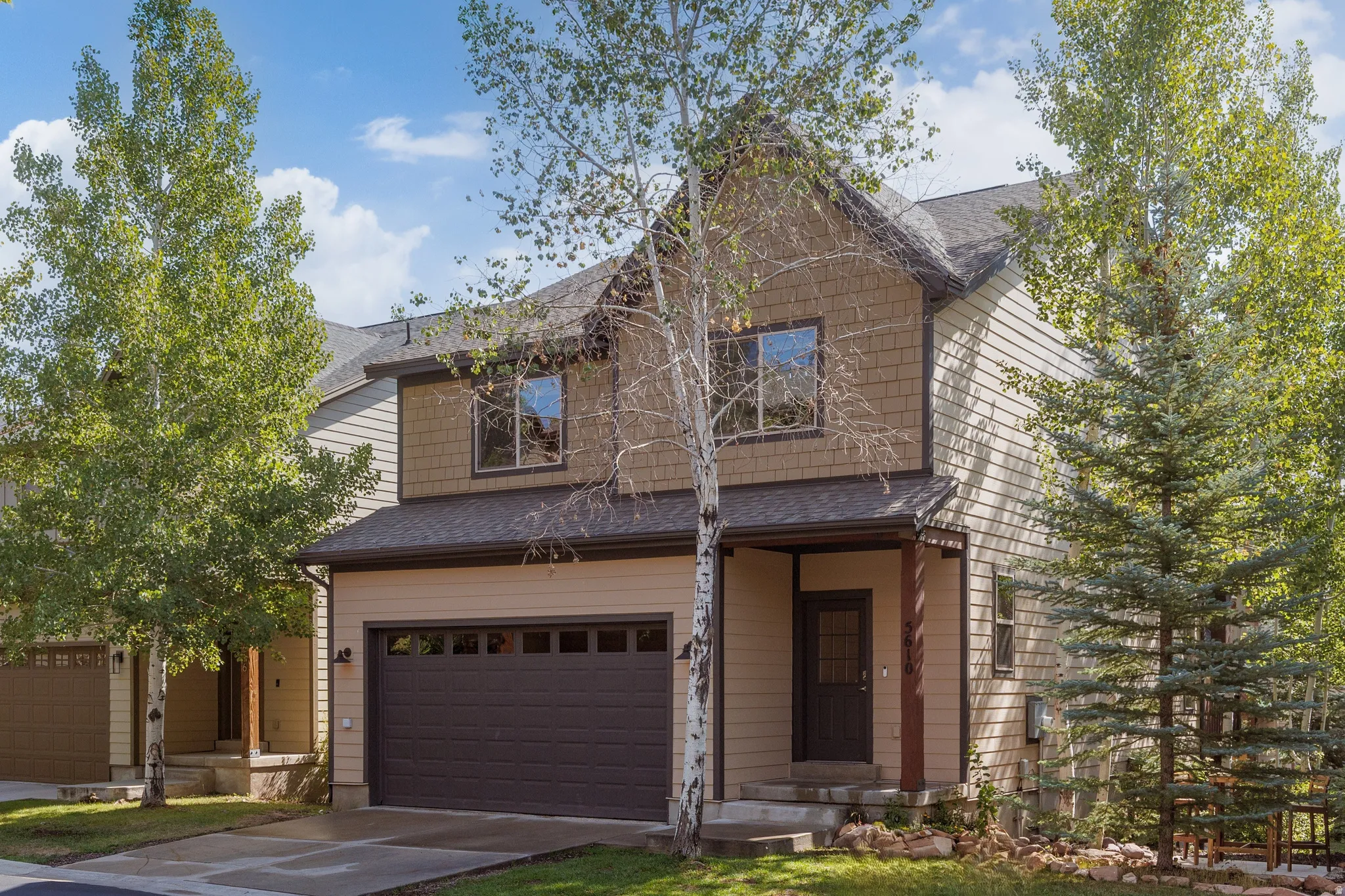 Two-story residence with walk-out basement on .083 acre featuring horizontal siding, shake siding, iron-ore color trim, and  attached two-car garage