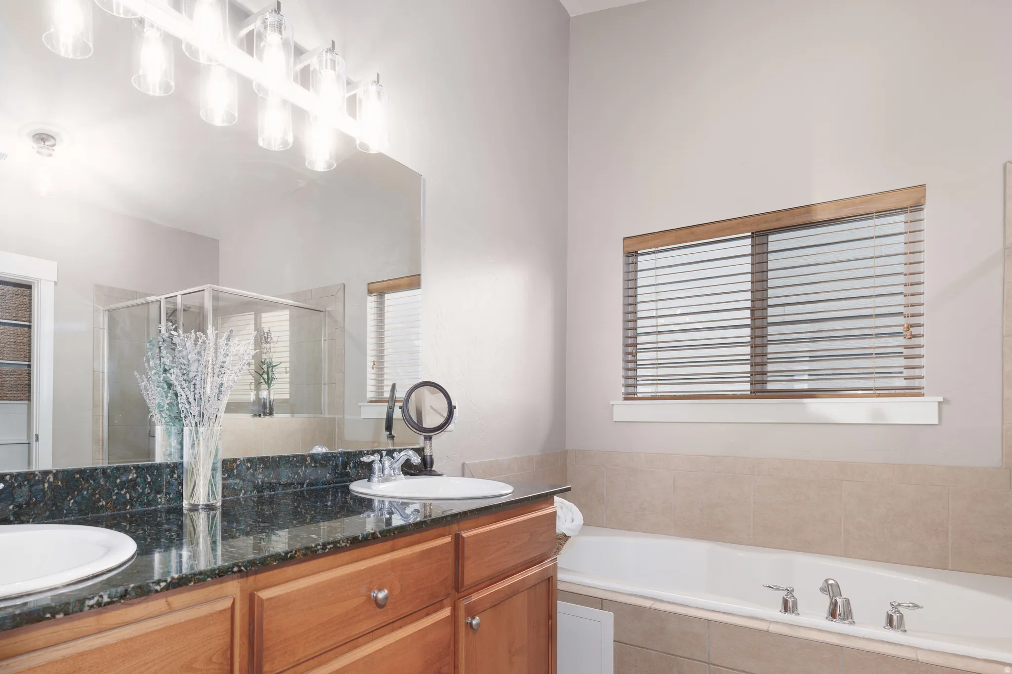 Dual vanity with undermount sinks, stone-look countertop, and wood-finish cabinetry