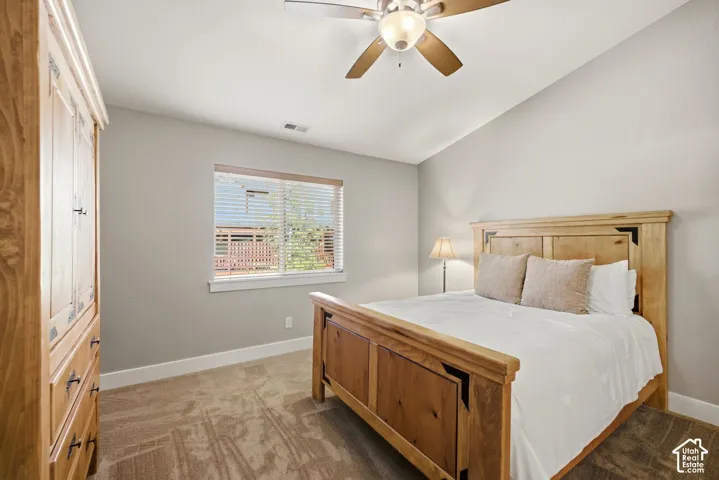 Neutral wall tones, textured carpeting, and a ceiling fan with integrated lighting