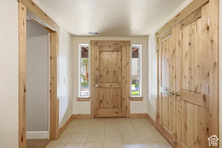 Natural wood-finish doors, tile flooring, and matching wood-finish trim throughout