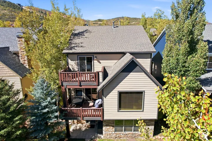 Multi-level balconies, stone veneer accents, and a shingled roof