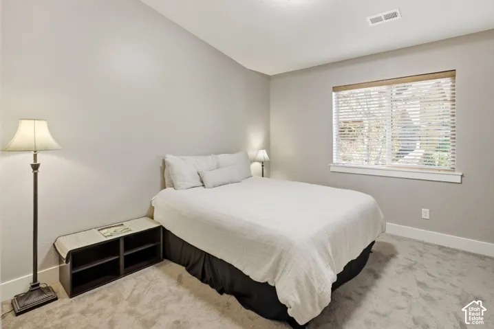 Neutral wall tones, window with natural light, white trim, and light gray carpeting
