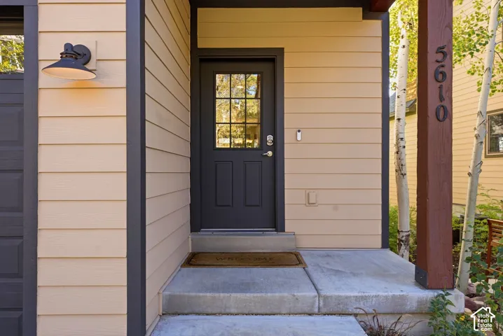 Entry featuring horizontal siding and dark trim