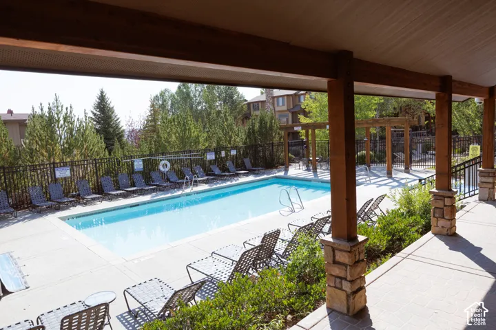 Expansive outdoor swimming pool and hot tub with surrounding patio