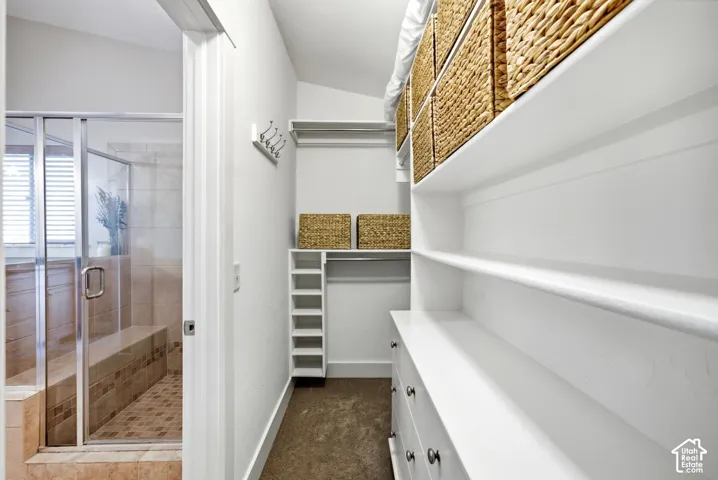 Glass-enclosed shower with tiled walls and built-in bench