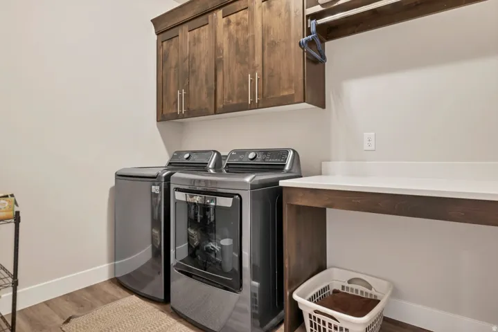 Built-in wood-finish cabinetry, white countertop, wood-finish shelving, and wood-finish flooring