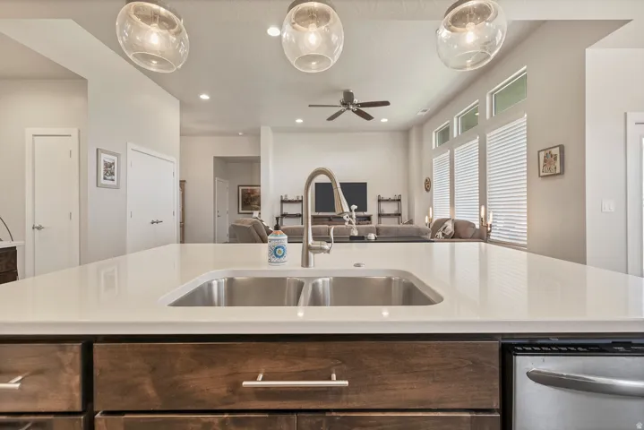 Spacious kitchen island with a double basin stainless steel sink, sleek faucet, and light-toned countertop