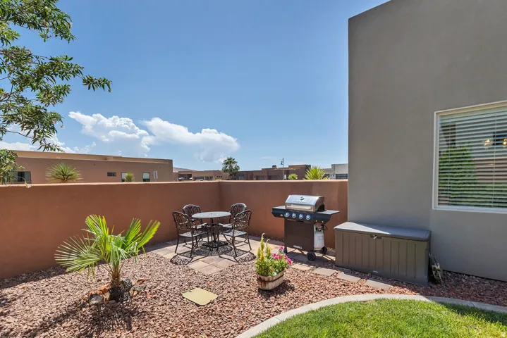Landscaped patio featuring a paver seating area, gravel accents, and a grass border