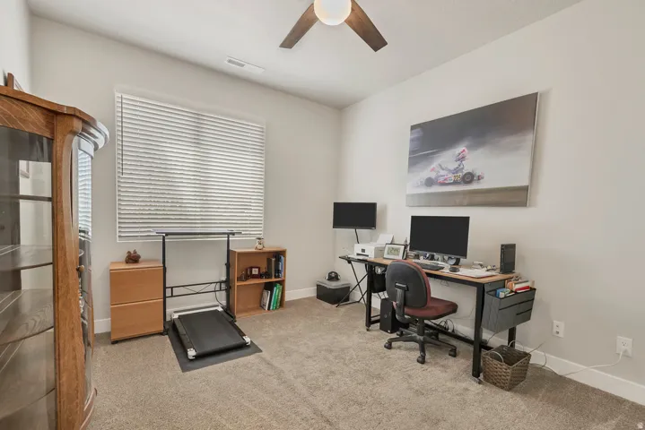 Carpeted room featuring a ceiling fan, a window with blinds, and light-colored walls