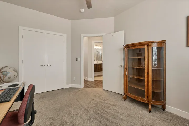 Soft grey carpeting with white trim and a ceiling fan