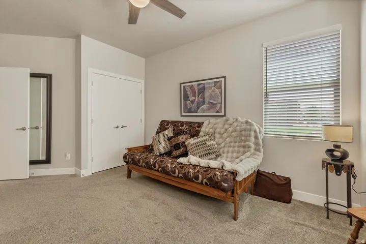 Recessed window with horizontal blinds, overhead ceiling fan with light, and light gray wall paint