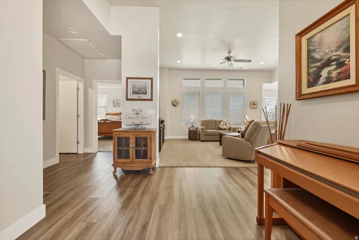 Wood-finish flooring extending into a carpeted living area with abundant natural light from multiple windows