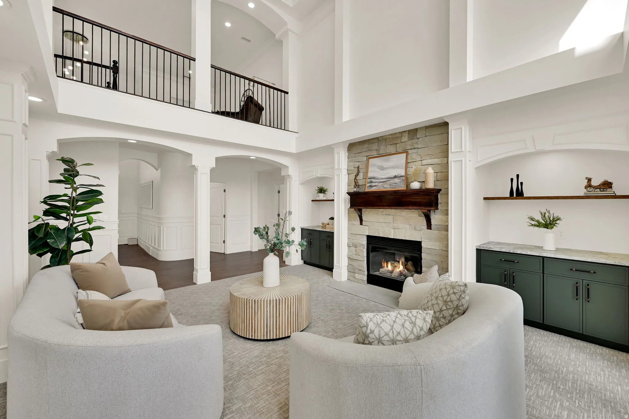 Two-story living area with stone-clad fireplace and wood mantel