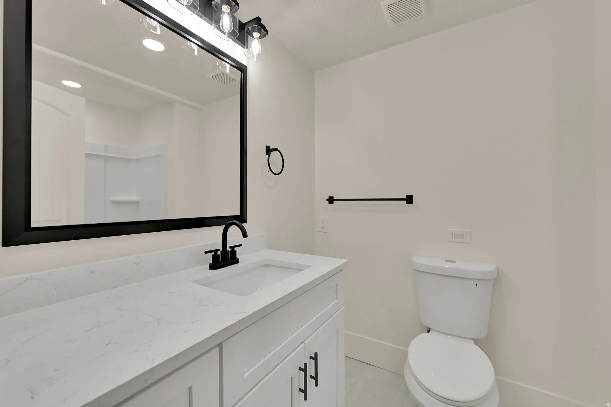 White vanity with shaker-style cabinetry, a white countertop, and an integrated rectangular sink