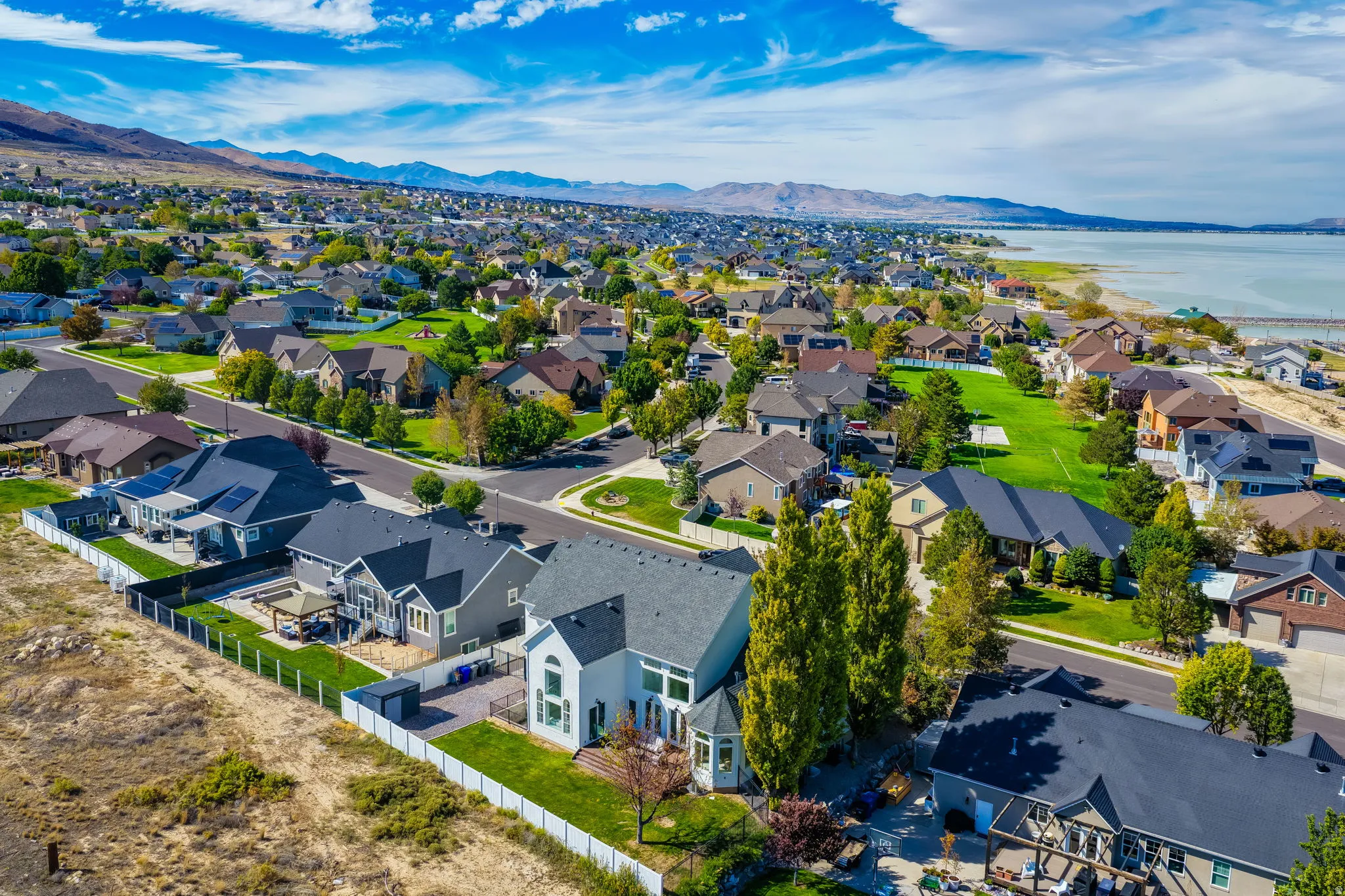 Residential neighborhood with mature trees, established landscaping, and mountain backdrop