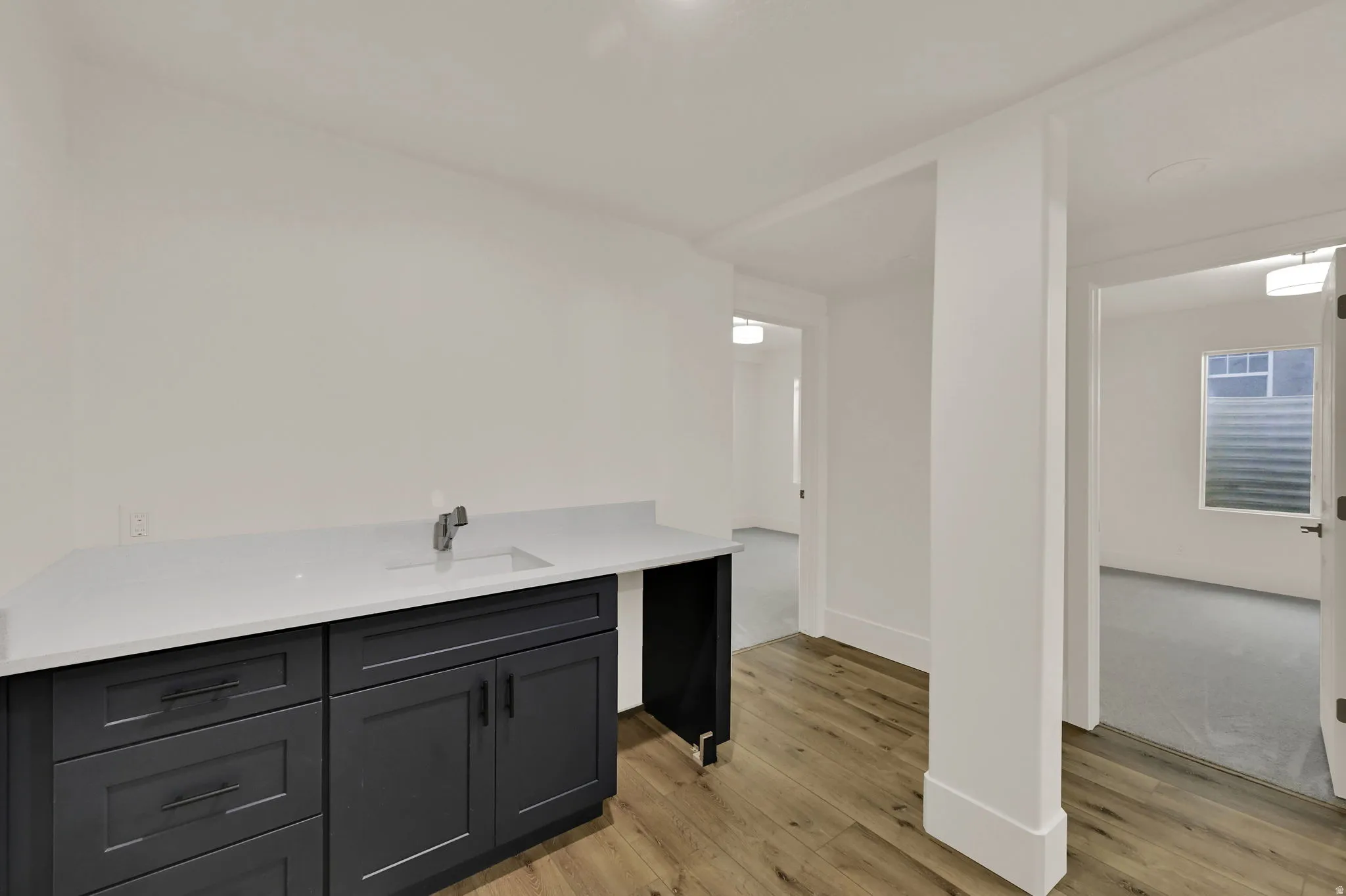 Built-in cabinetry with a white countertop and undermount sink