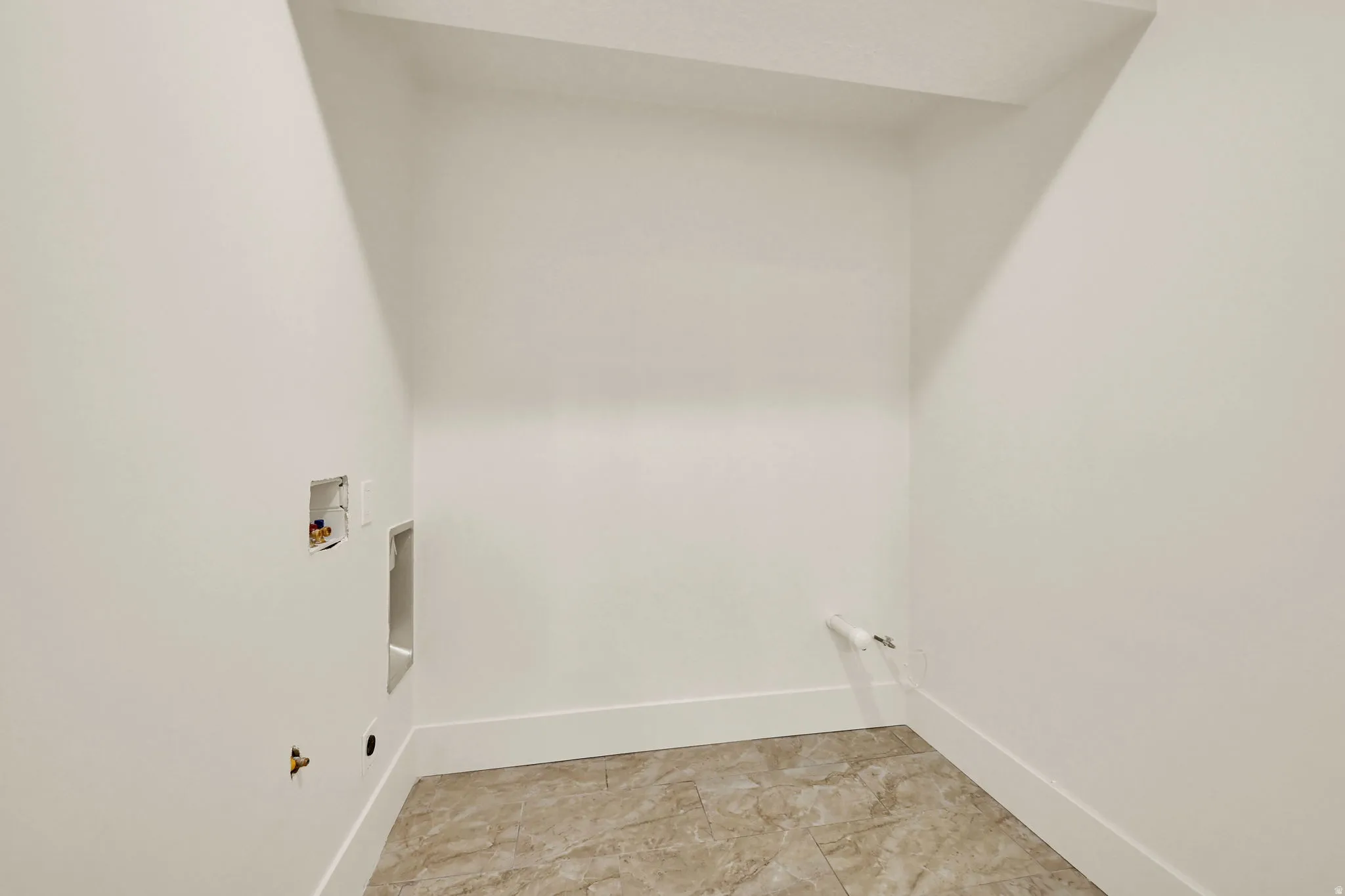 Laundry area featuring tile flooring, white walls, and utility hookups