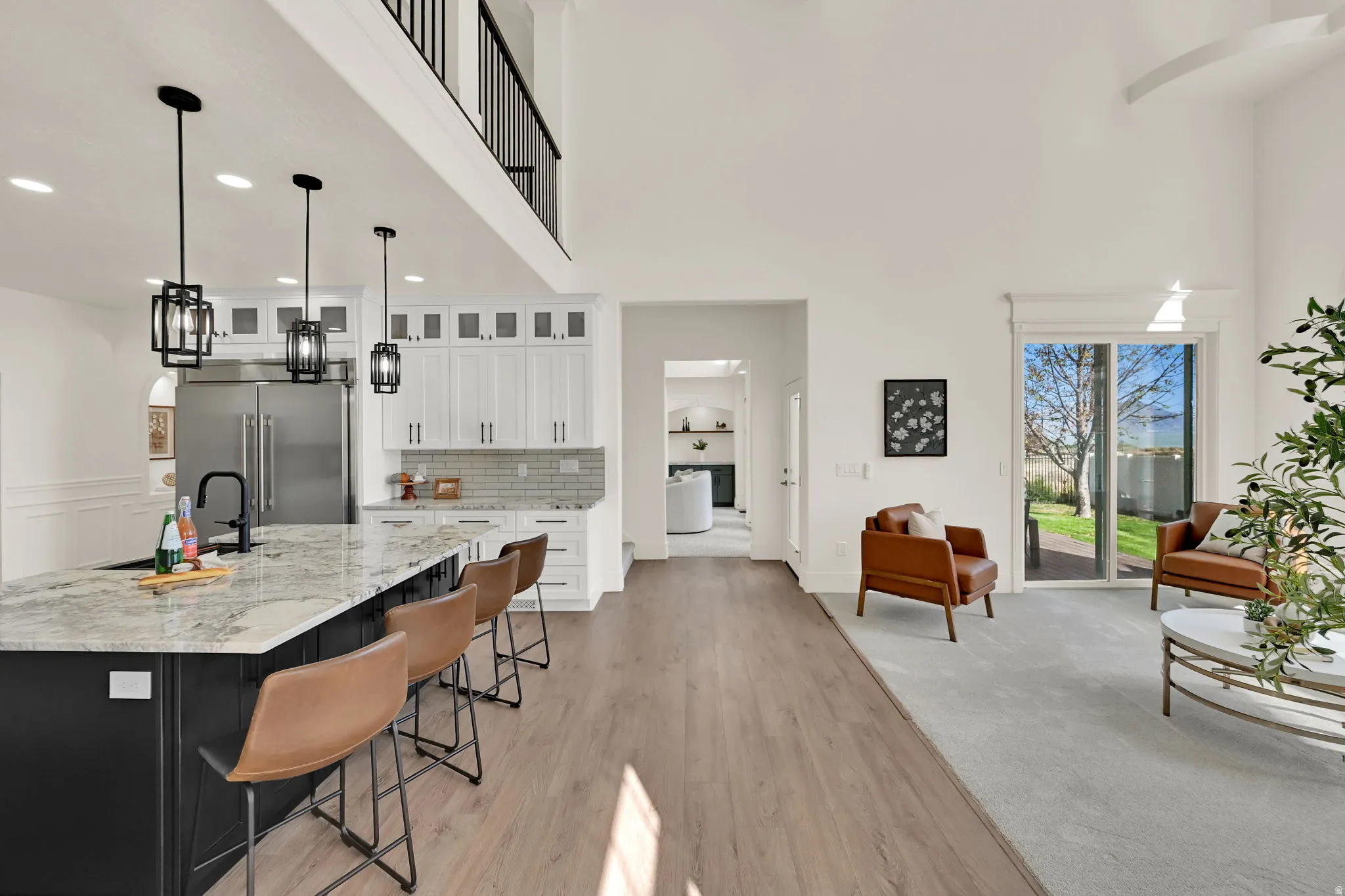Open-concept living area with vaulted ceilings, wood-finish flooring, and a kitchen island featuring a light-colored countertop