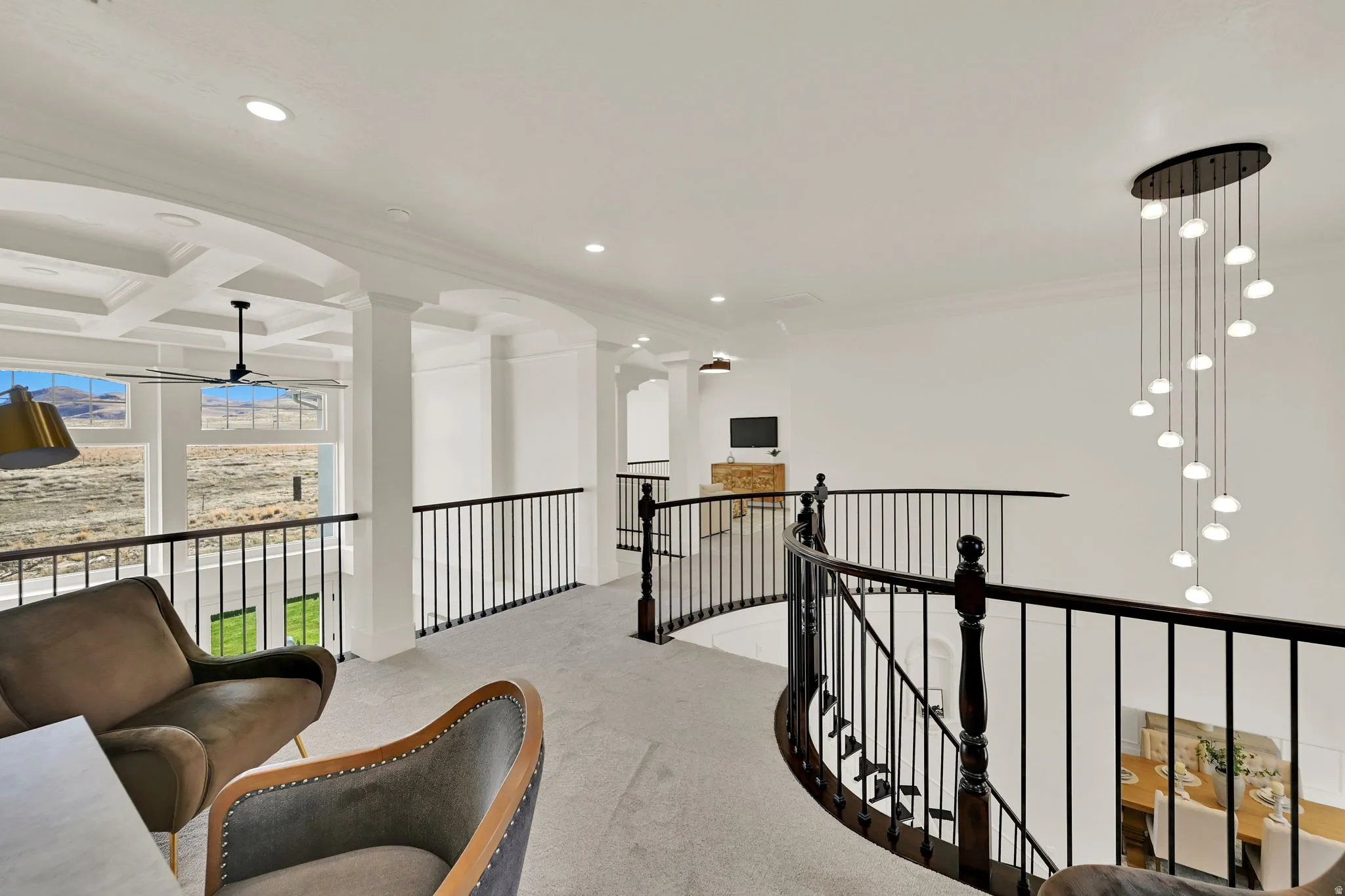 Upper-level landing with coffered ceiling detail, recessed lighting, and a modern tiered pendant light fixture