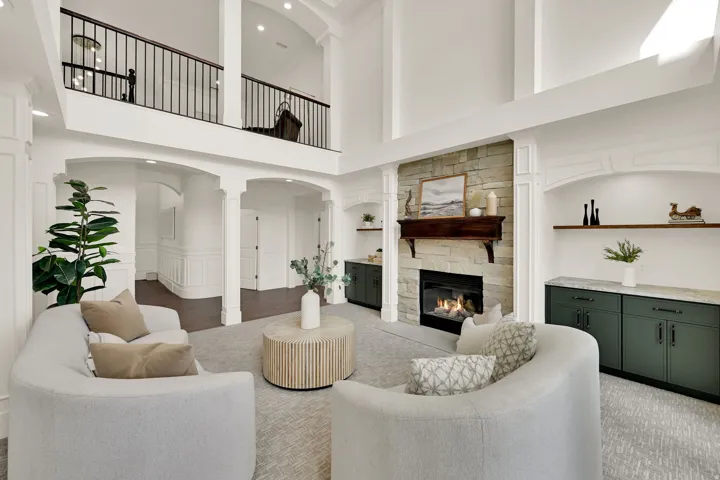 Two-story living area with stone-clad fireplace and wood mantel