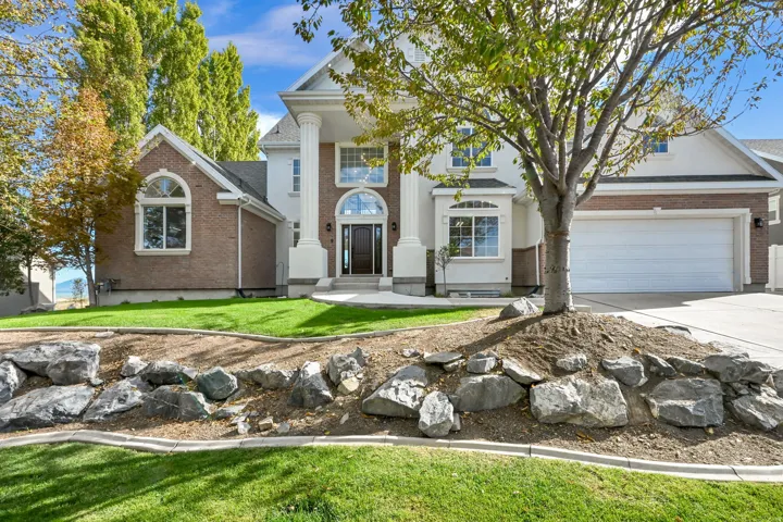 Stucco and brick exterior with a prominent portico entrance featuring two large columns