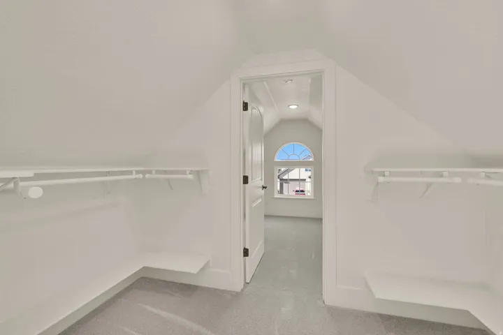 Built-in shelving with hanging rods in closet leading to a secret room with a window!