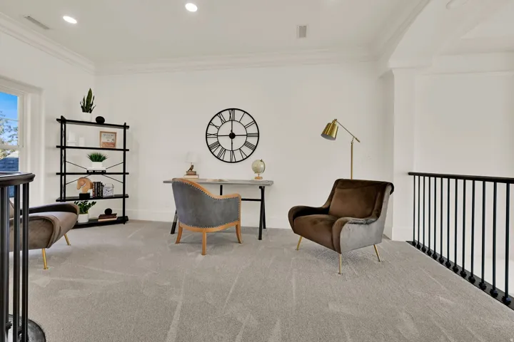 Loft area featuring light-toned carpeting, white walls, recessed lighting, crown molding, and black metal railings