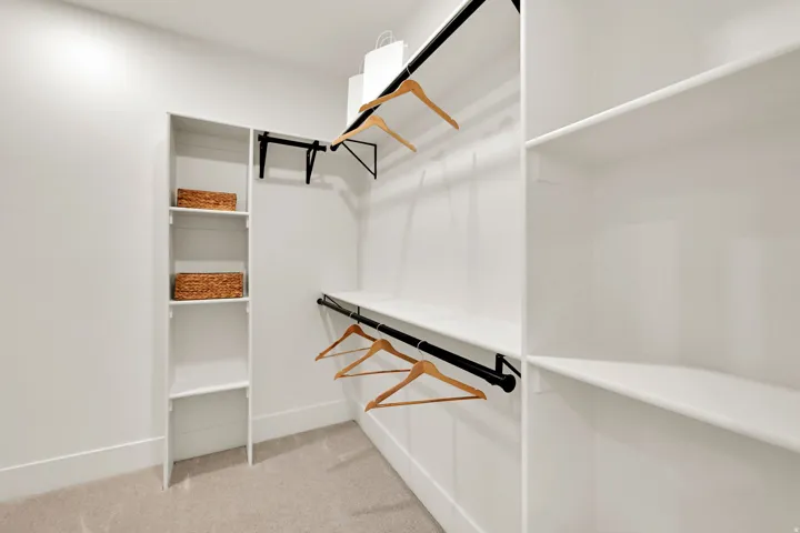 Primary Suite his/her walk in closets with integrated closet system featuring multiple shelves and hanging rods & Stackable washer/dryer!