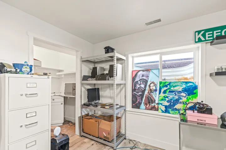 White interior walls, wood-finish flooring, and a built-in shelving unit