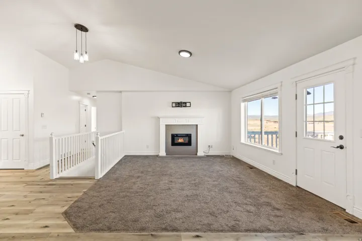 Vaulted ceilings, a built-in fireplace, and a large window with exterior access