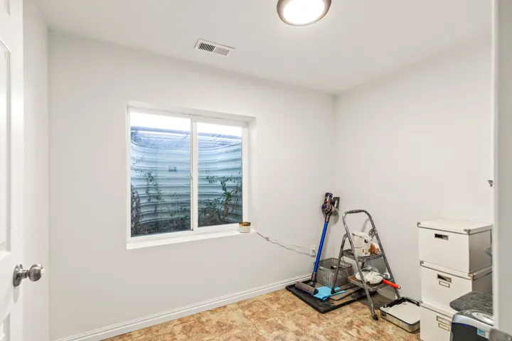 White interior walls with a single window and recessed ceiling light