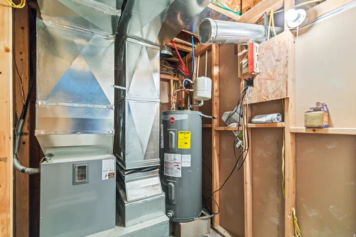 Forced-air furnace system with extensive ductwork, water heater, and exposed wood framing