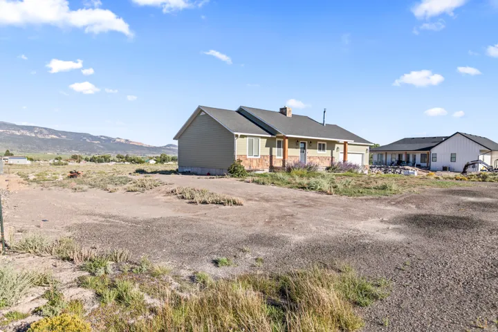 Ranch-style residence featuring a stone veneer facade, attached two-car garage, and a covered front porch with wood columns